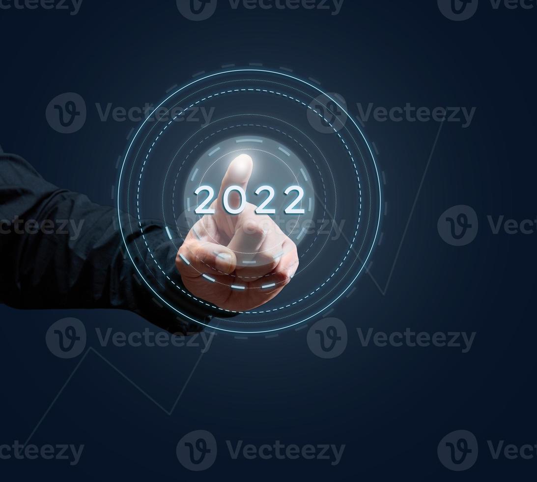 man's hand of a businessman presses on the virtual button of the beginning of the year. Business opening and new sales markets, the beginning of a new life photo