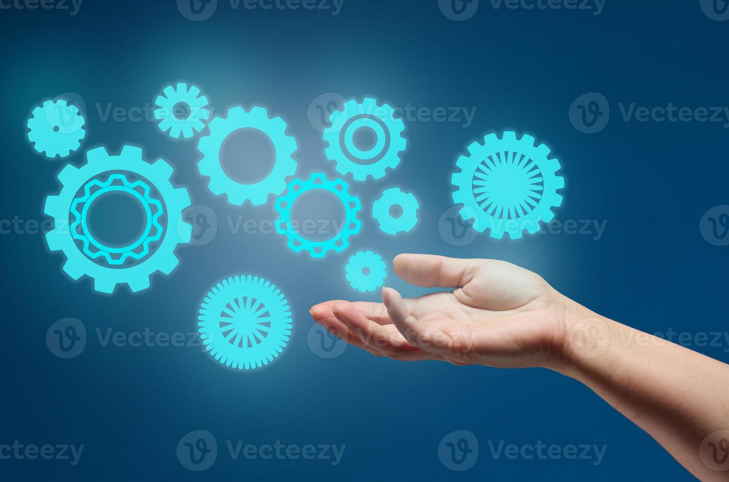 gear wheels and female hand on a blue background. Business structure precise work concept, team unification photo