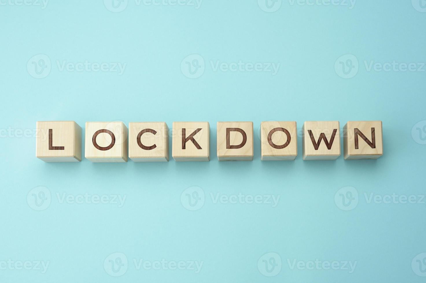 wooden blocks with the inscription lockdown on a blue background. Self-isolation concept to prevent the spread of viruses in settlements photo