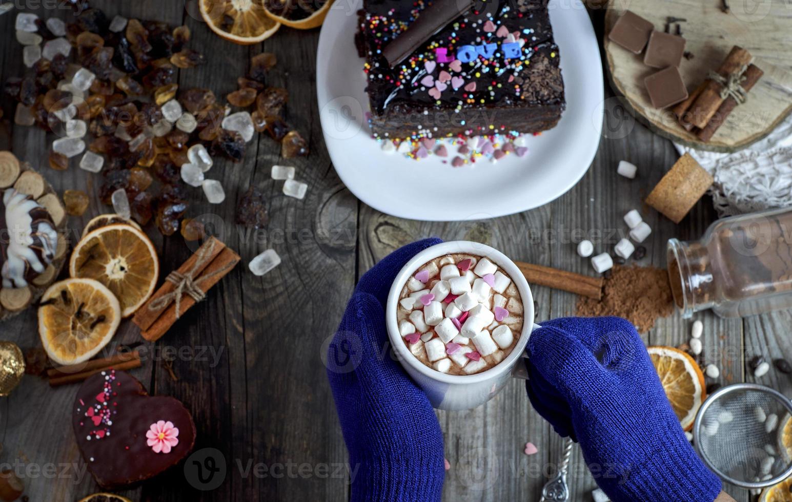 pair of female hands with blue gloves holding a mug photo