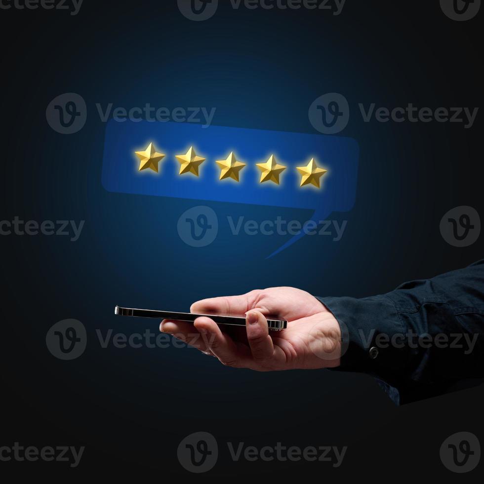 a man's hand holds a smartphone and five gold stars above it. App evaluation. User reviews photo