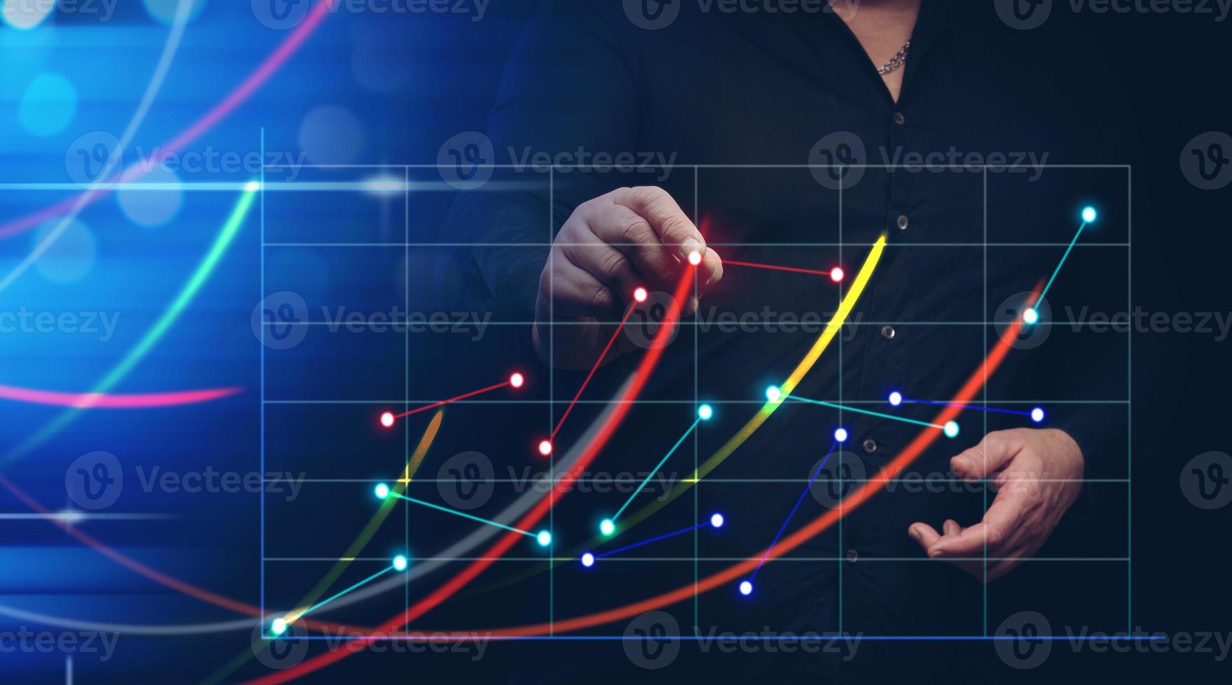 a man in a black shirt stands in front of a holographic graph with growing indicators. Business growth, sales increase. High performance photo