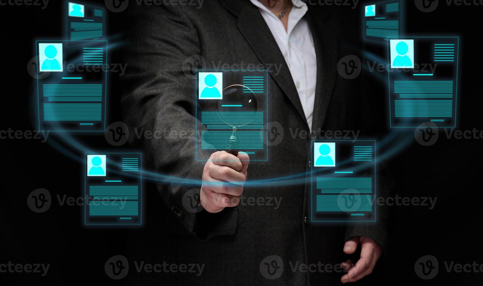 businessman stands with a magnifying glass around a holographic screen with virtual resume. Selection of a candidate, search for a talented employee. Career growth photo