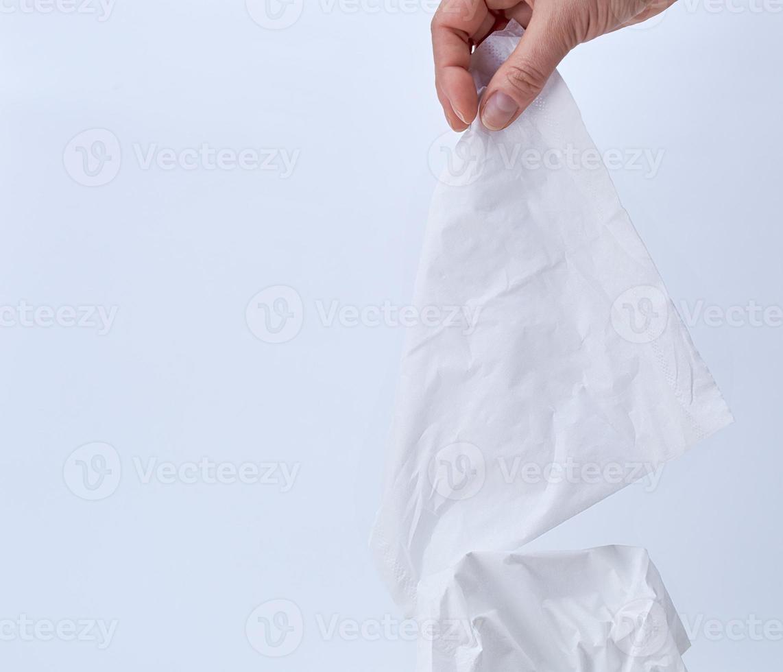 female hand holding a clean white paper napkin for face and body photo