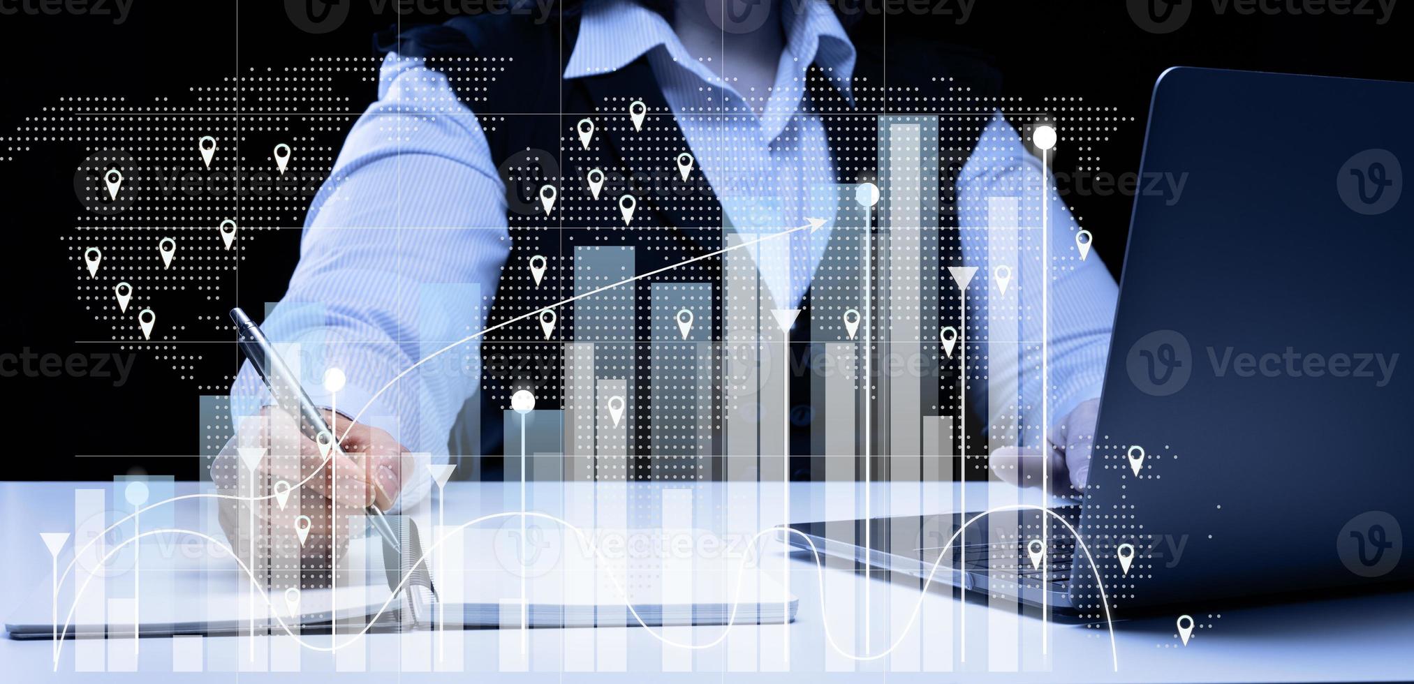 woman sits at a laptop in front of a holographic chart with growing indicators. Business development, high financial performance, success. photo