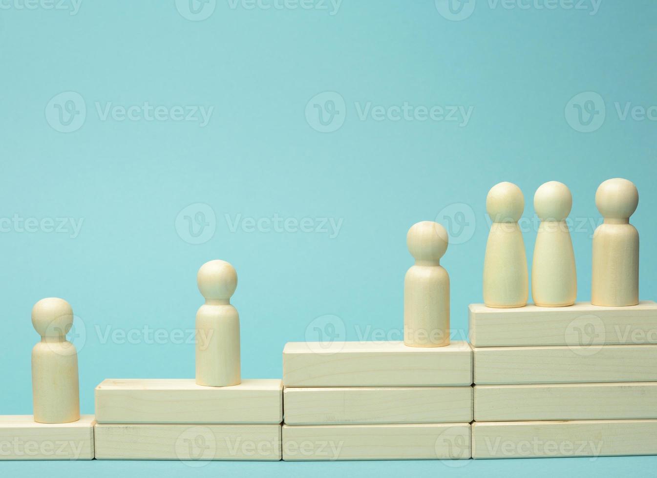 wooden figures of men on a ladder made of blocks. The concept of career advancement, starting at work, achieving goals photo