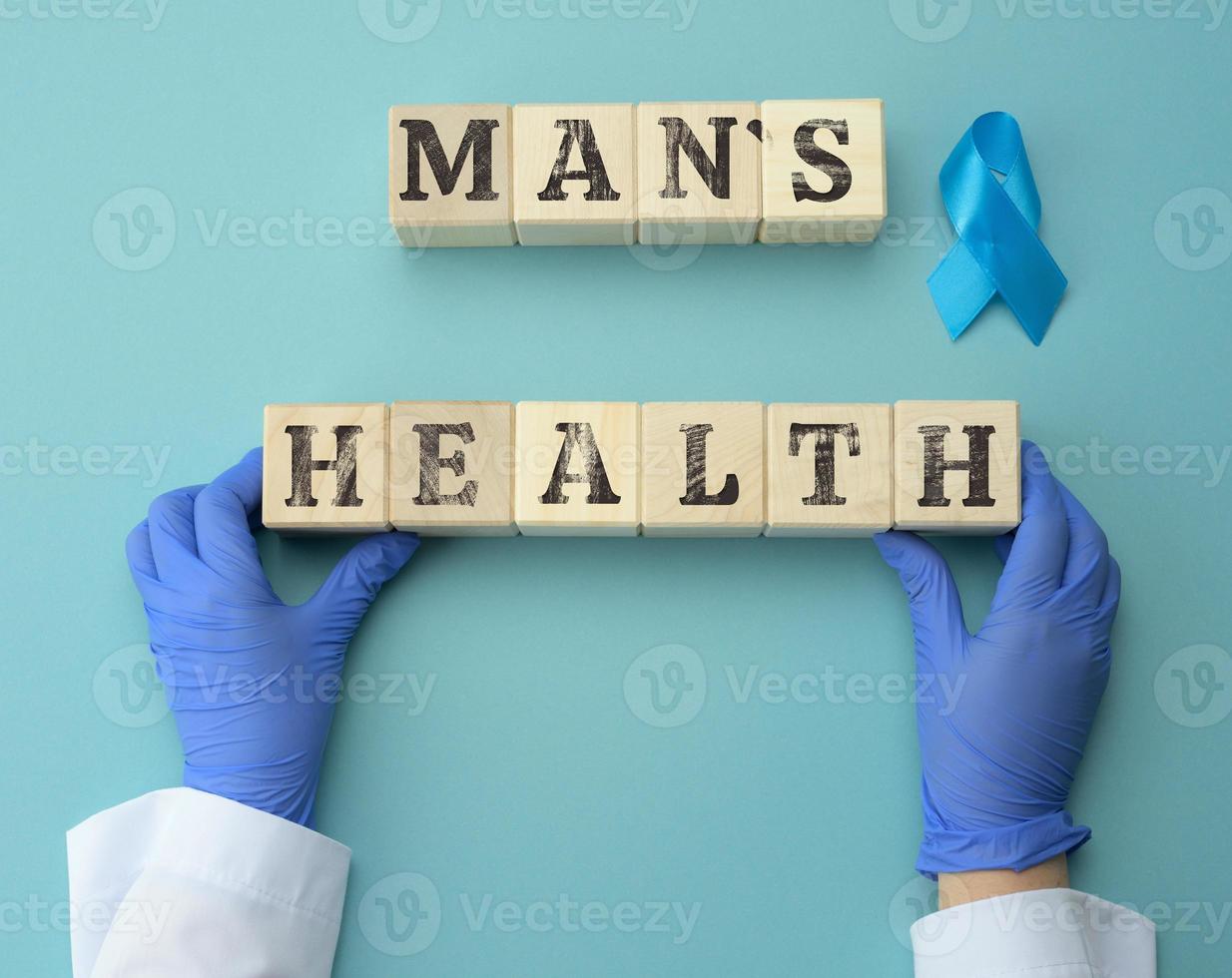 de madera cubitos con el inscripción del hombre salud y dos manos de un médico en azul guantes. concepto para oportuno diagnóstico de próstata cáncer en hombres foto