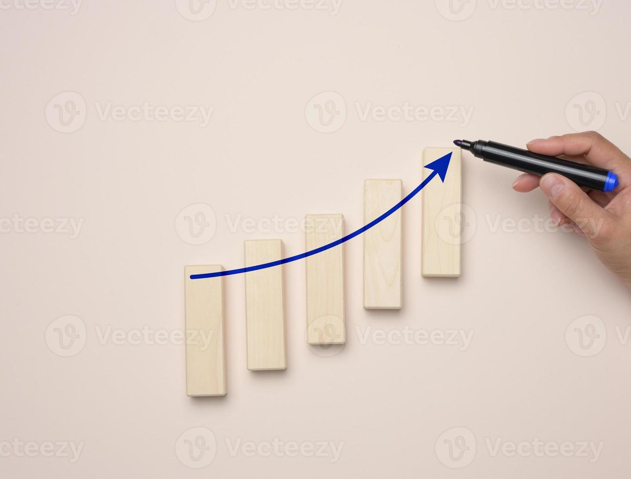 Graph with growing indicators and a female hand with a marker on a blue background. photo