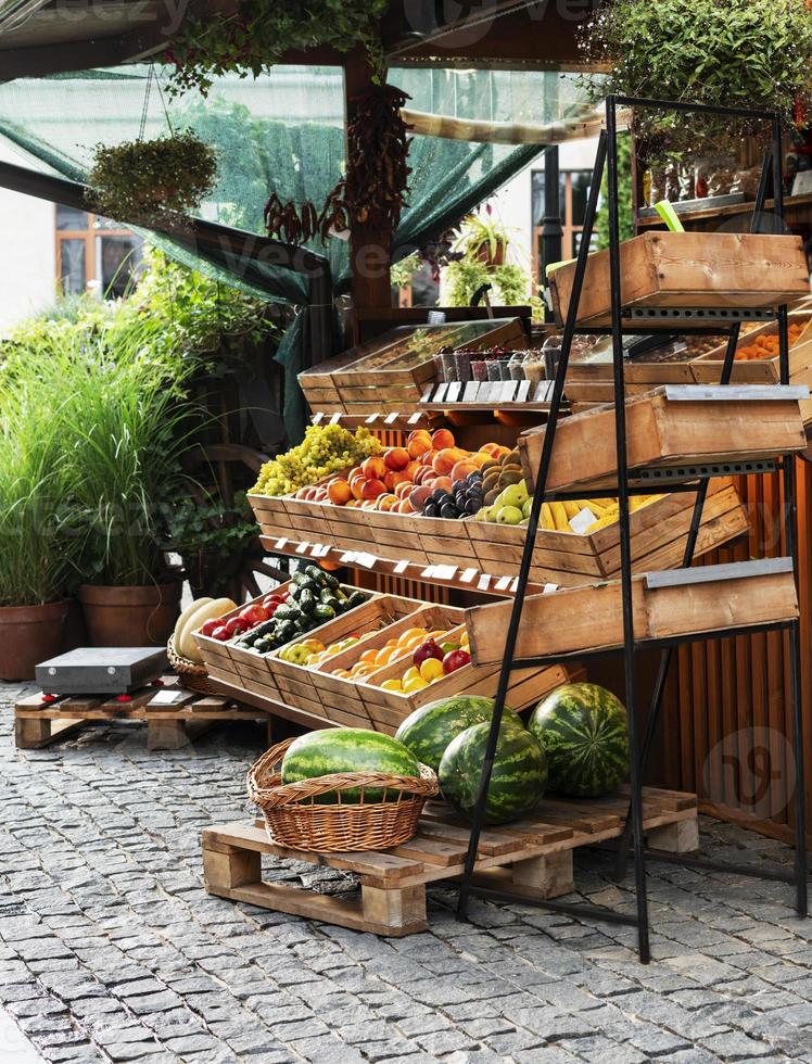 Fruit stand at a street market outside with watermelons, oranges, lemons in wooden crates small business healthy food photo