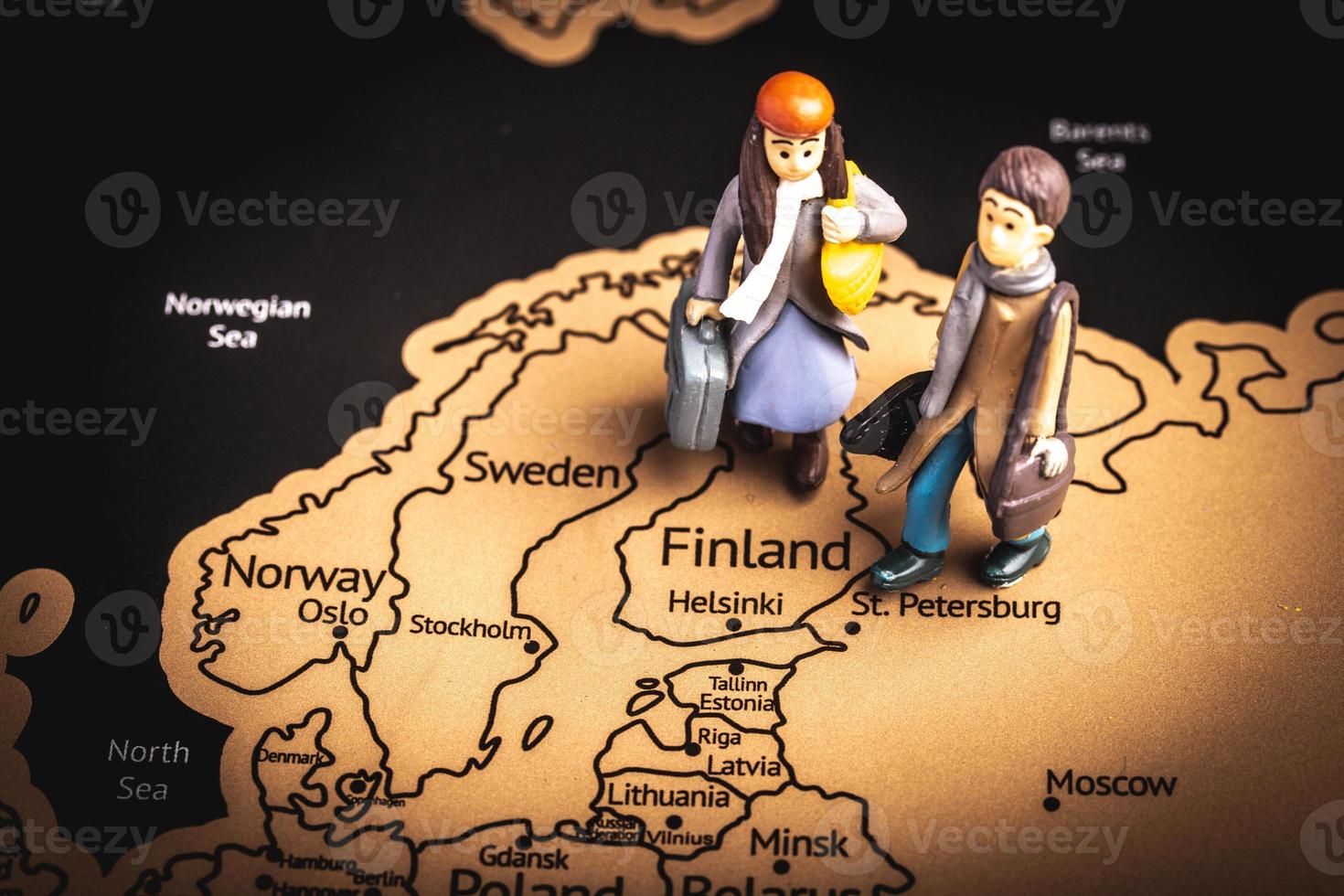 Miniature people with traveling concepts. Miniature traveler with baggage walking on the world map photo