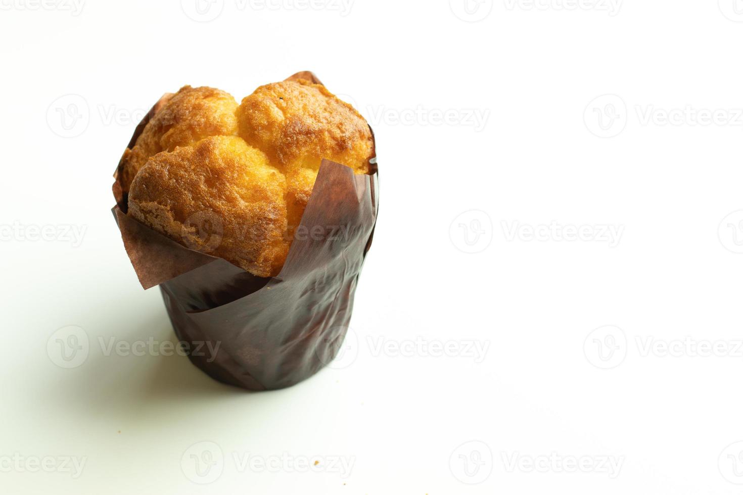 Vanilla cupcake muffin in wrapper on white background isolate. Copy space photo