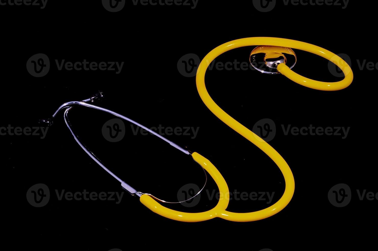 Yellow stethoscope on black background photo