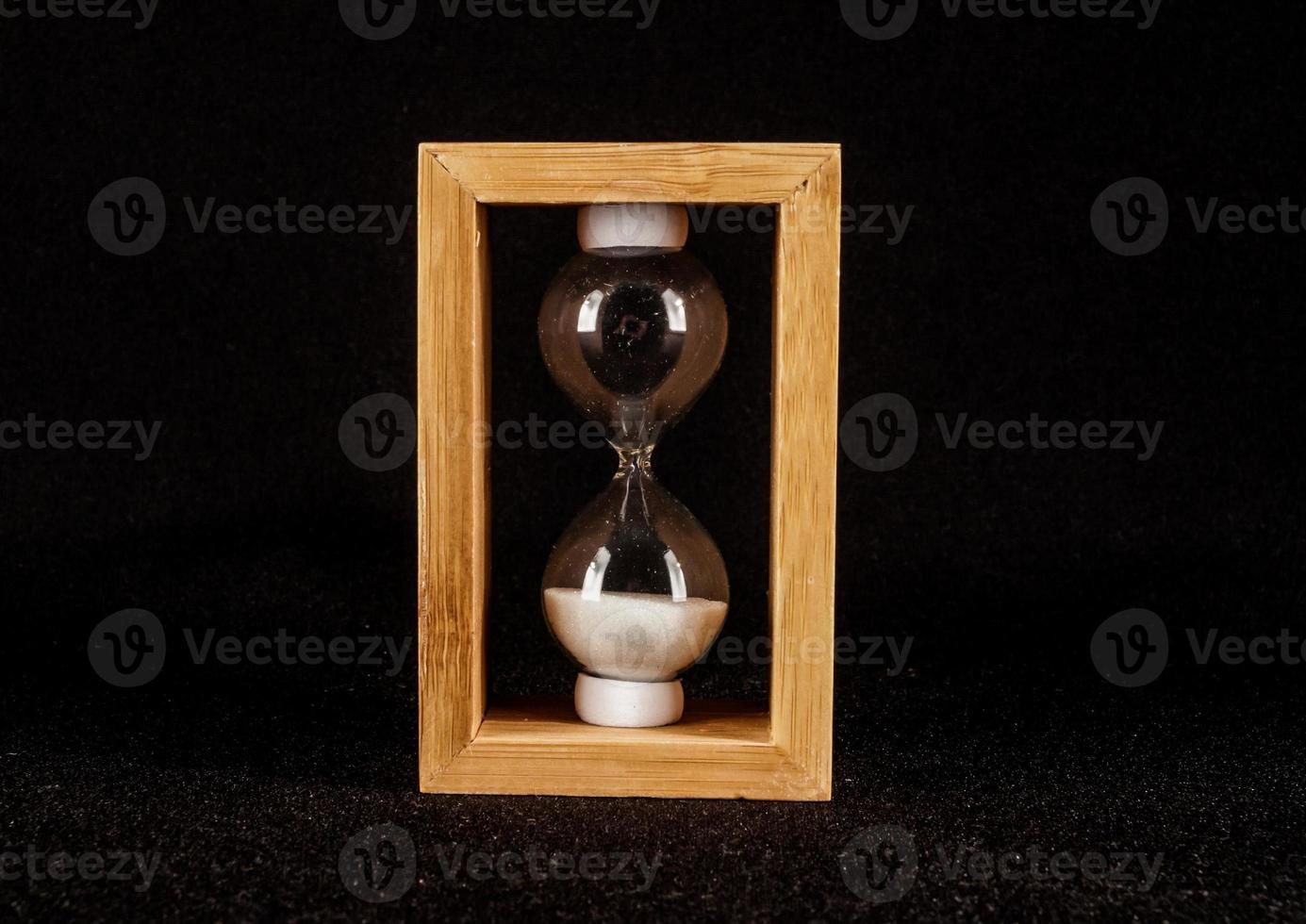 Hourglass on black background photo