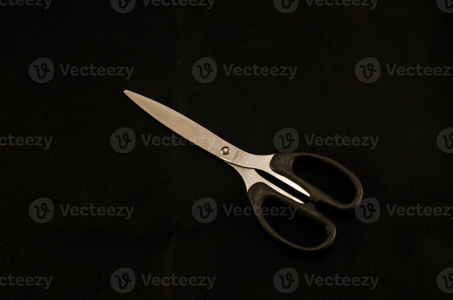 Scissors on black background photo