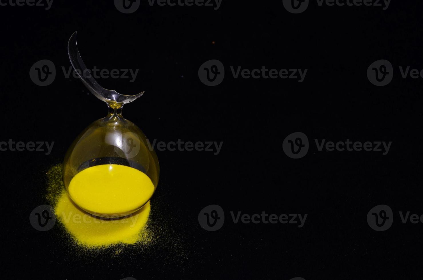 Hourglass with yellow sand photo