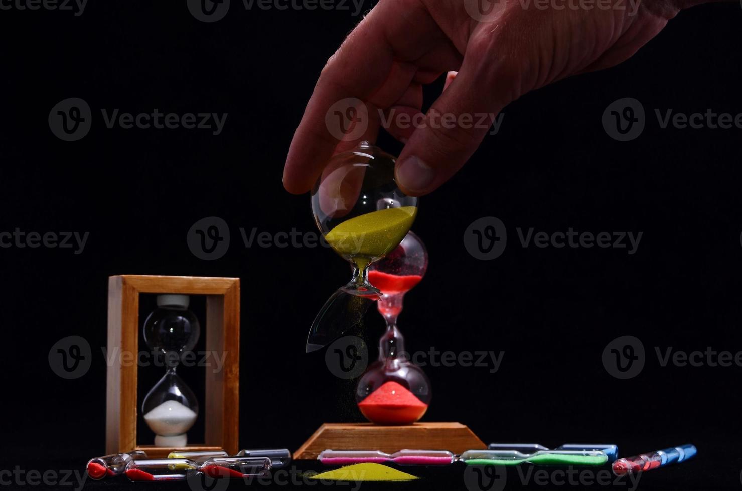 Hourglasses on black background photo