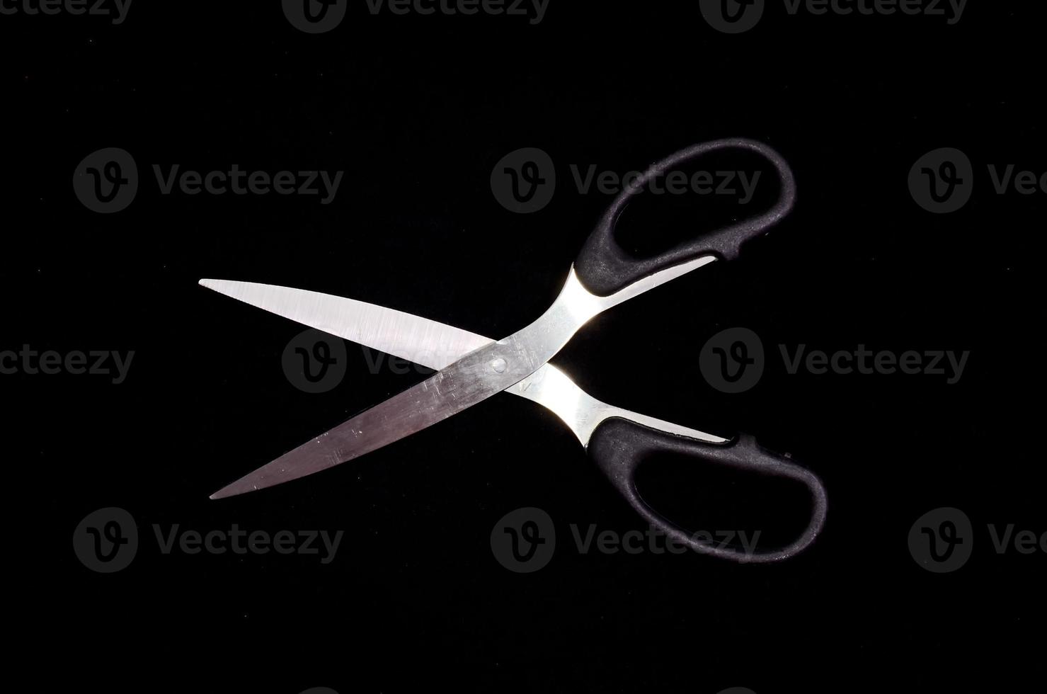 Scissors on black background photo