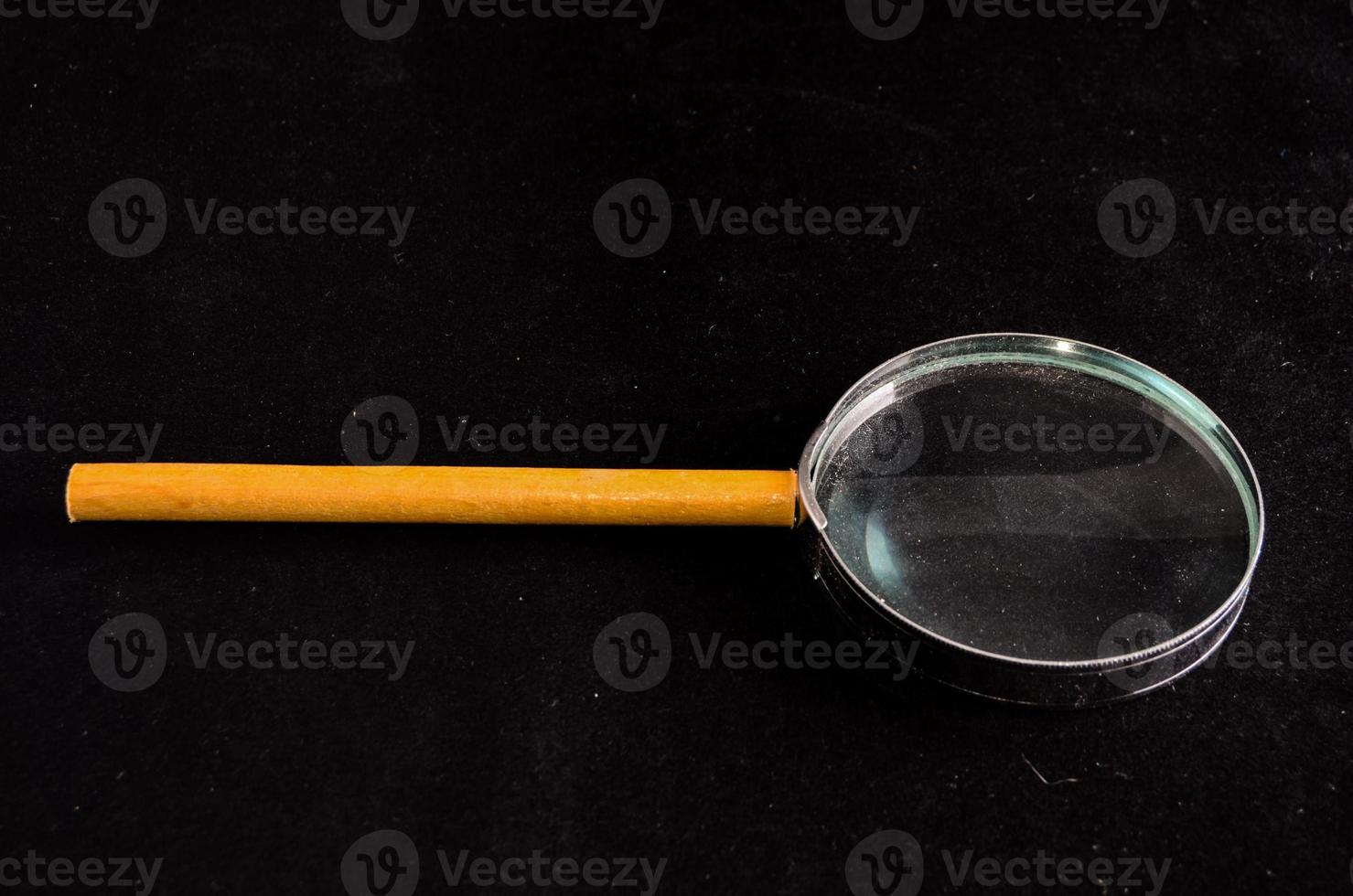 Magnifying glass on black background photo