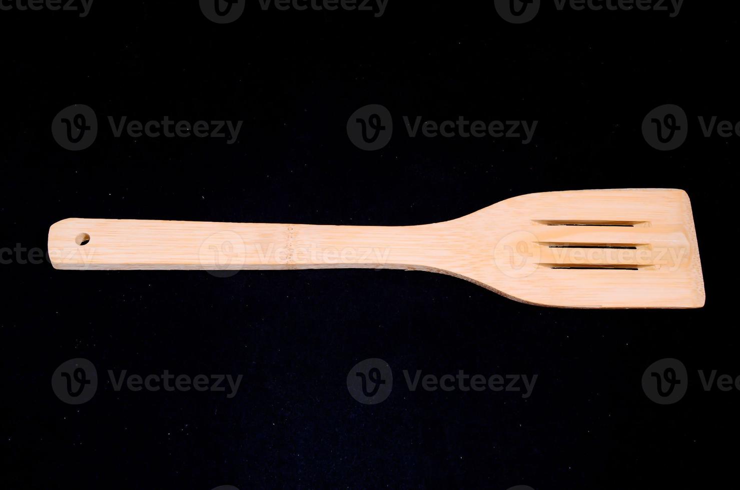 Wooden spoon on black background photo
