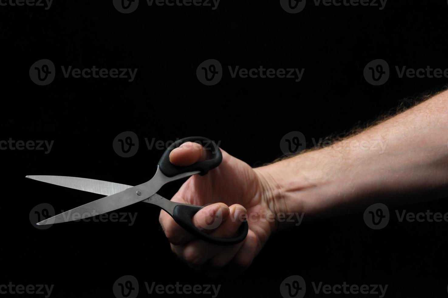 Opening scissors on black background photo