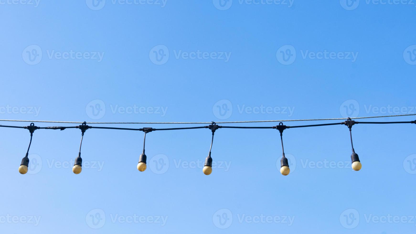 Round tube external lamp. Continue lined up on the rope. under the blue sky for background. photo