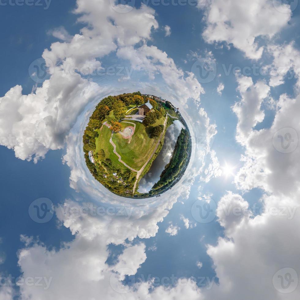 pequeño planeta en el cielo con nubes que dominan el casco antiguo, el desarrollo urbano, los edificios históricos y los cruces. transformación del panorama esférico 360 en vista aérea abstracta. foto