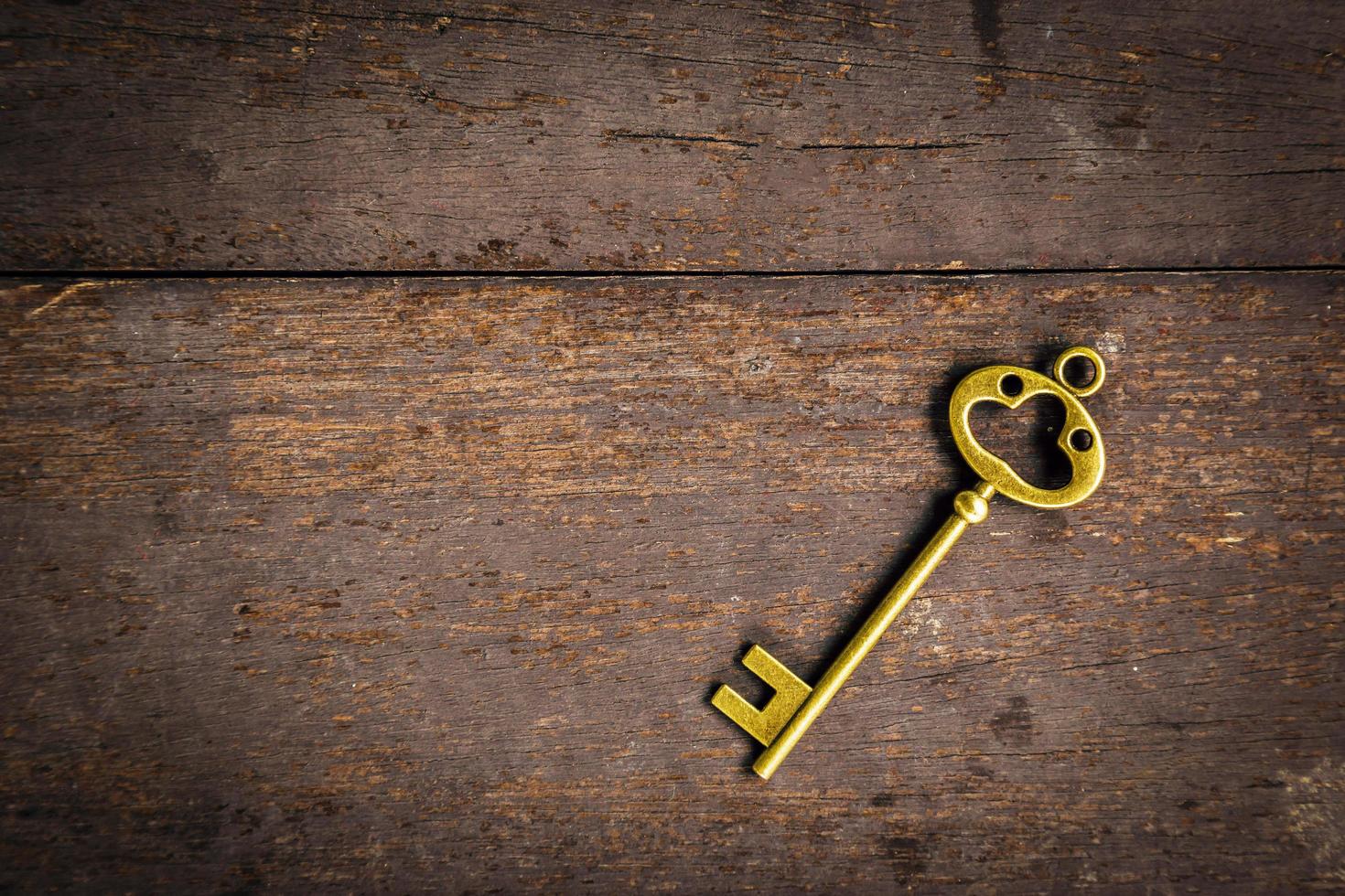 Old vintage key on wood texture background with space photo