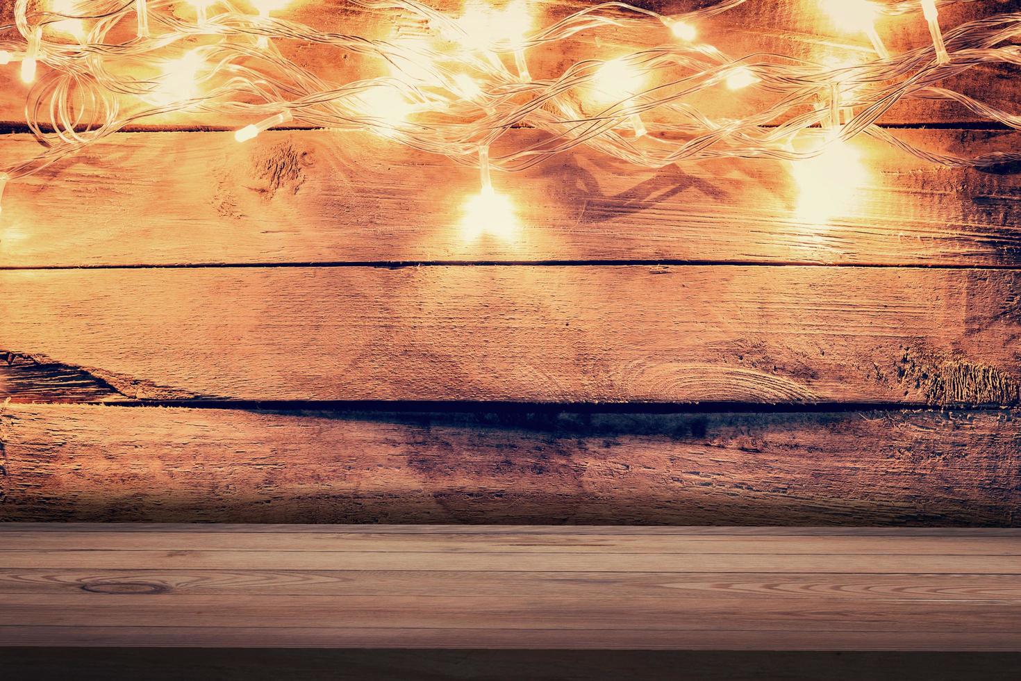 Christmas light on wooden background and wooden table. Christmas table background with space for product. photo