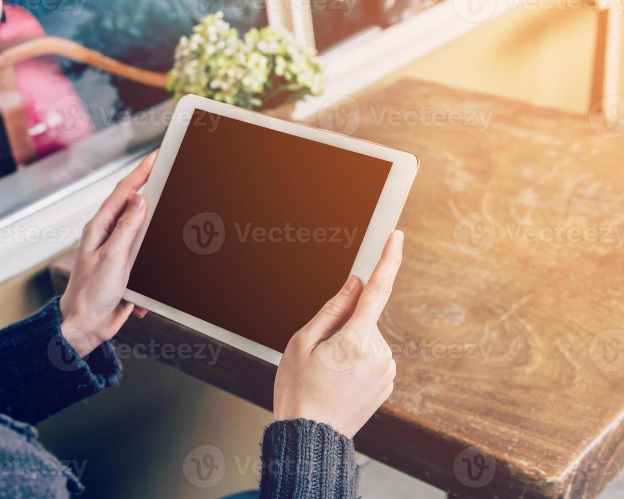 Asian woman using tablet computer in coffee shop with Vintage tone. photo