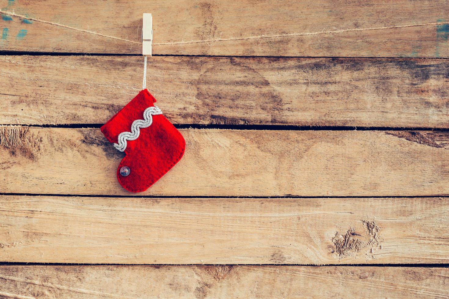 red sock for Santa gifts hanging over rustic wooden background. christmas stocking photo