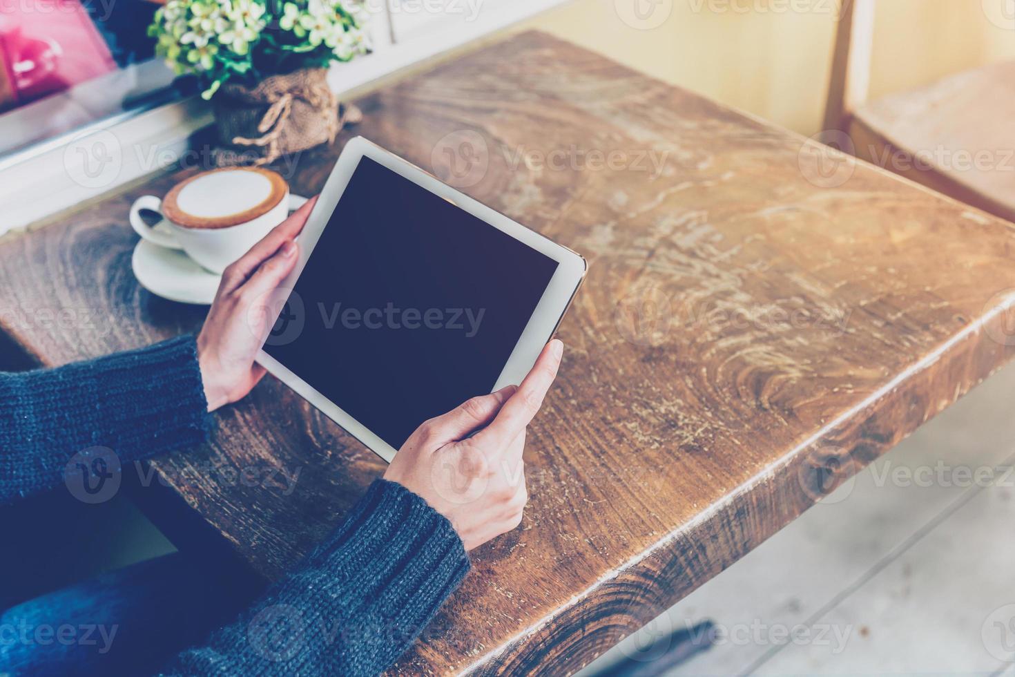 Woman using tablet in coffee shop with vintage tone. photo