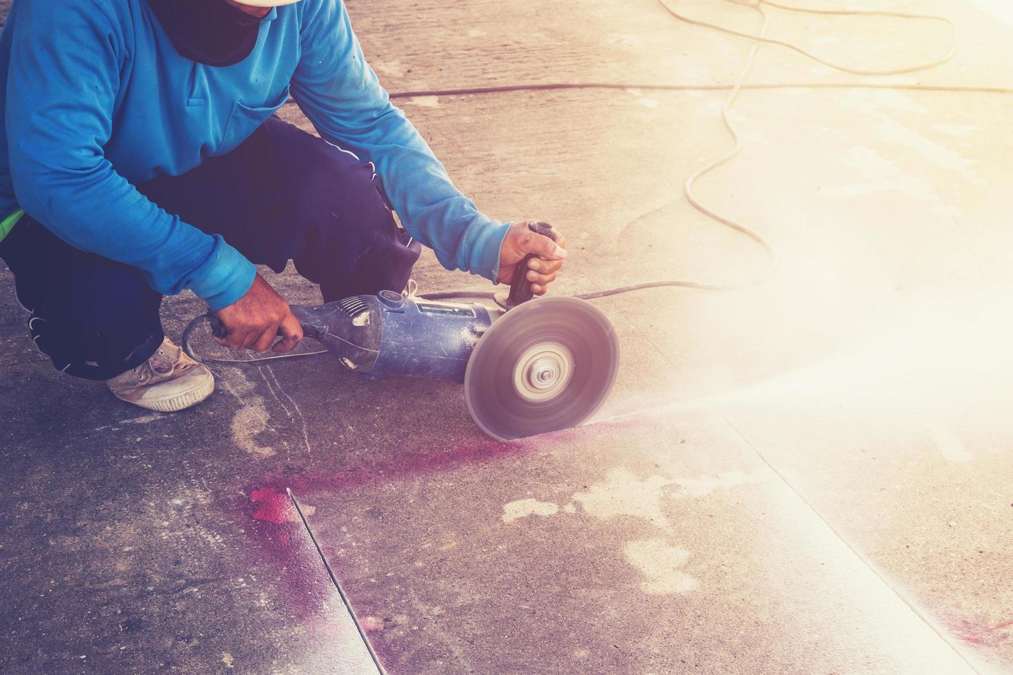 Close up hand man cutting concrete floor with machine. photo