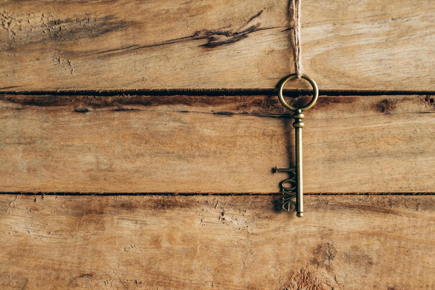 old key hanging on brown wood and Love concept. photo