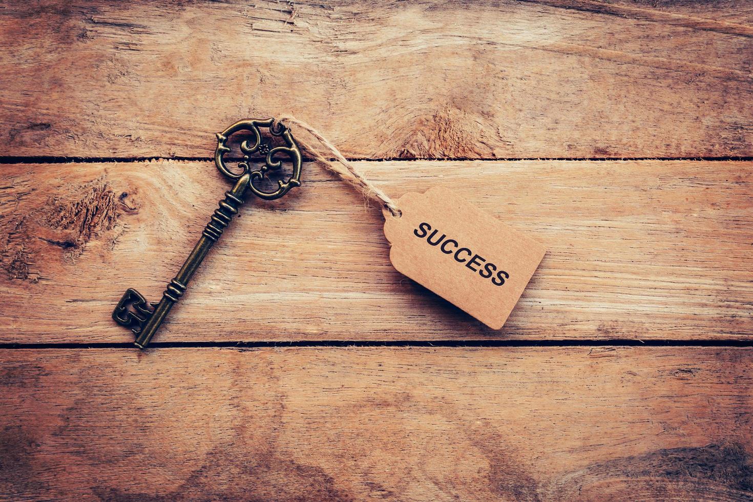 Business concept - Old key vintage on wood with tag Success. photo