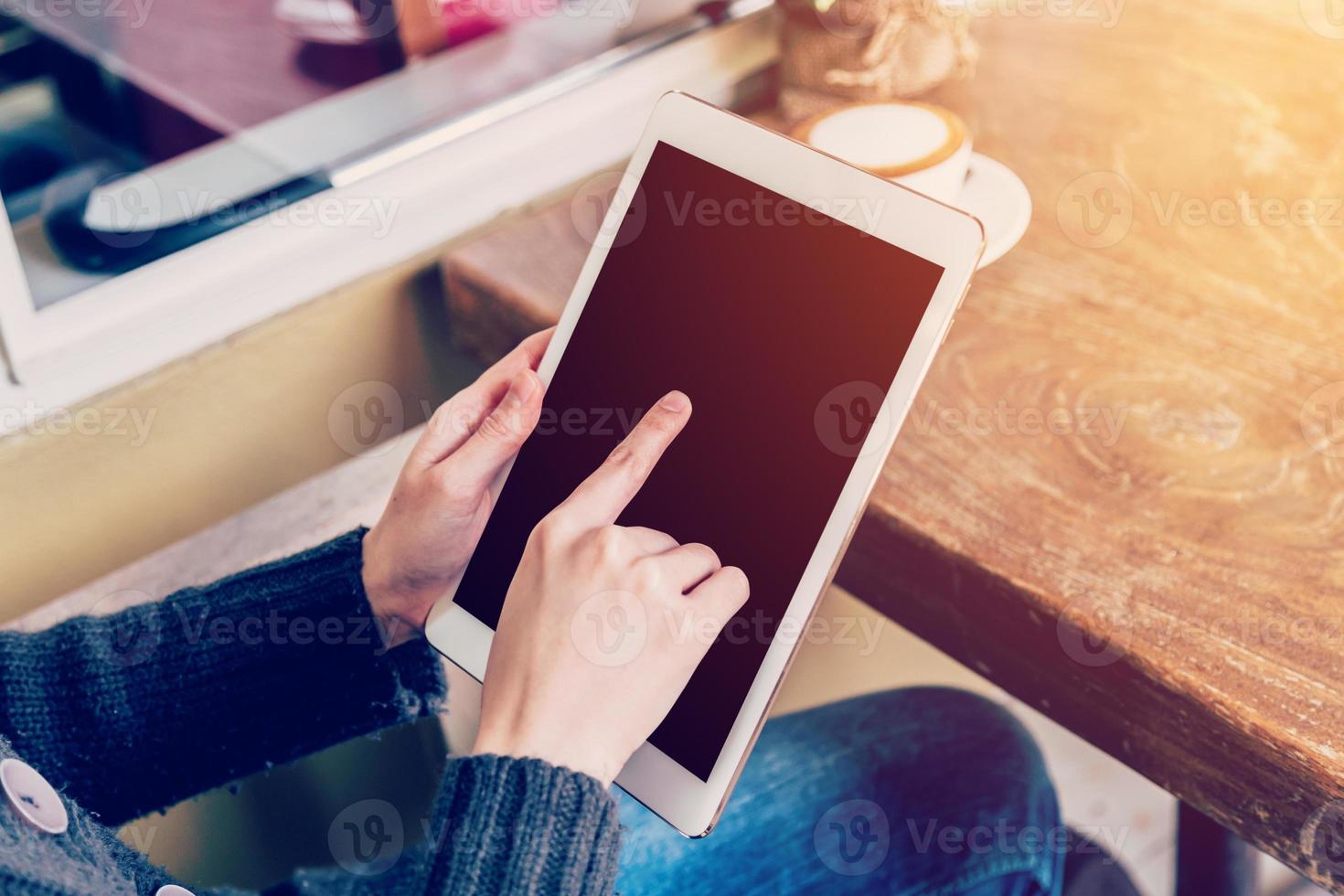 Asian woman using tablet computer in coffee shop with Vintage tone. photo