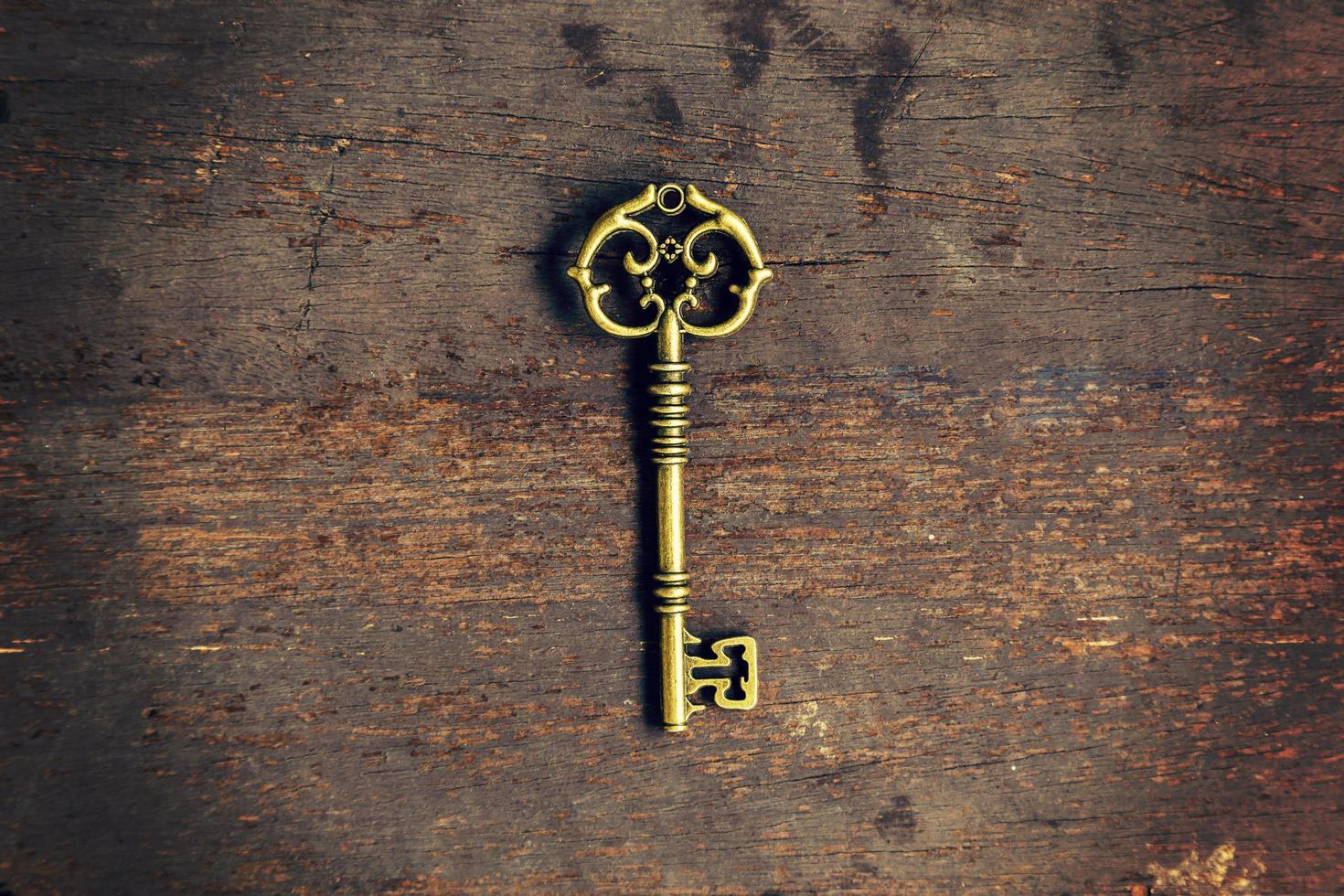 Old vintage key on wood texture background with space photo