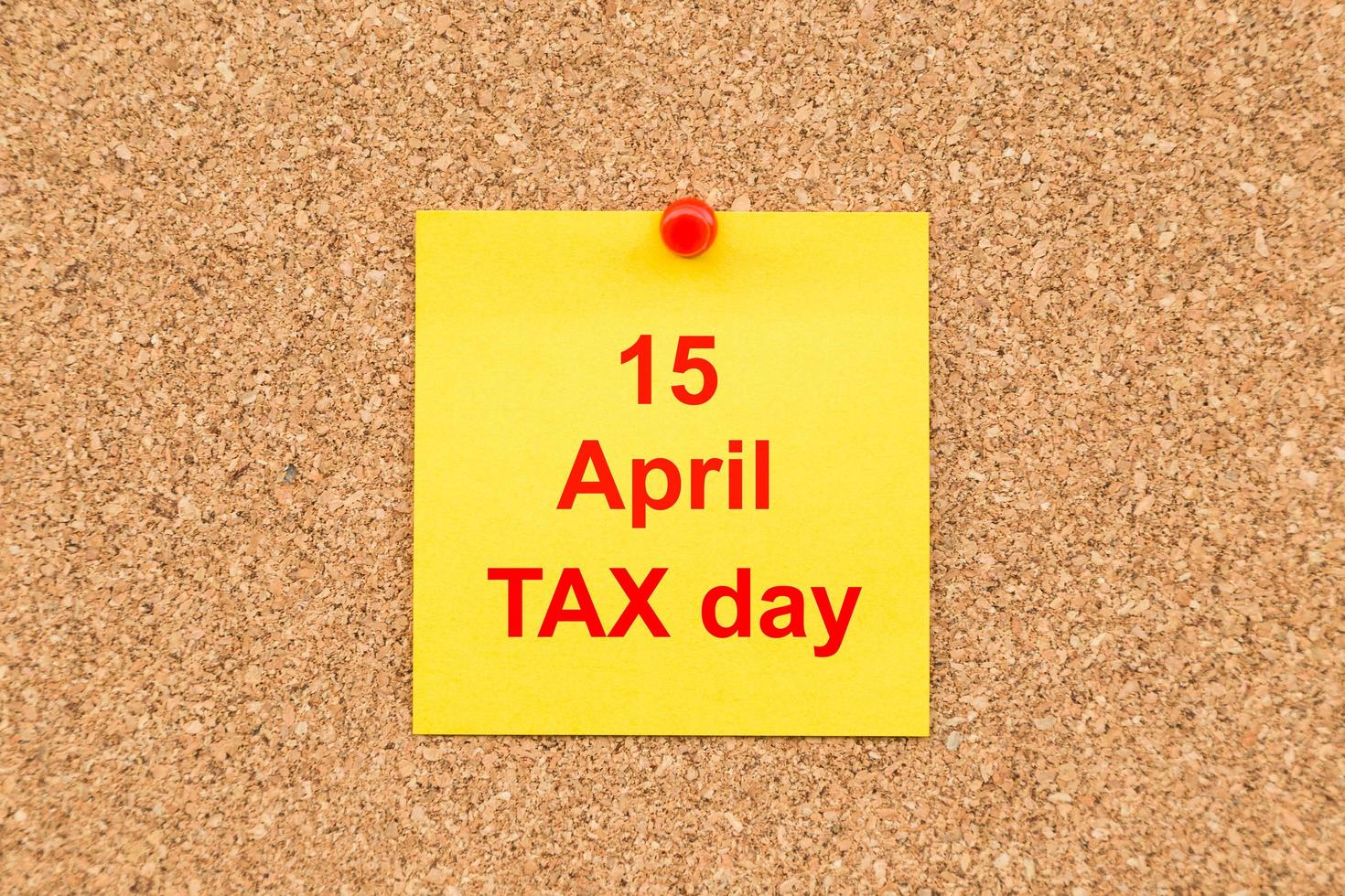 Yellow blank note and written 15 April TAX Day  for reminder. photo