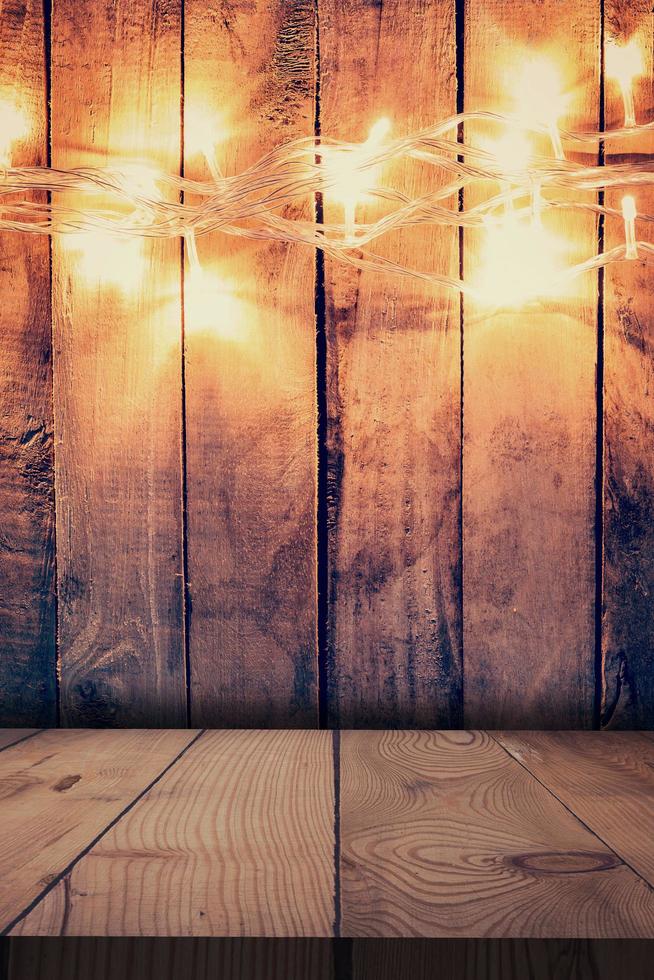 Christmas light on wooden background and wooden table. Christmas table background with space for product. photo