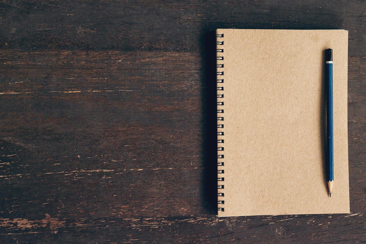 Top view notebook and pen on wood table with space, Vintage filter. photo