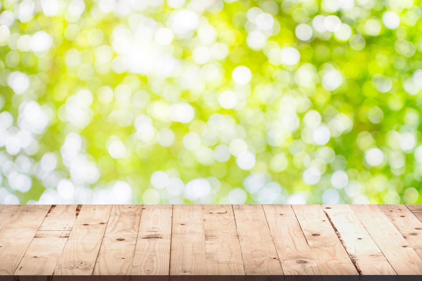 green bokeh display and wooden table background with space for product. photo