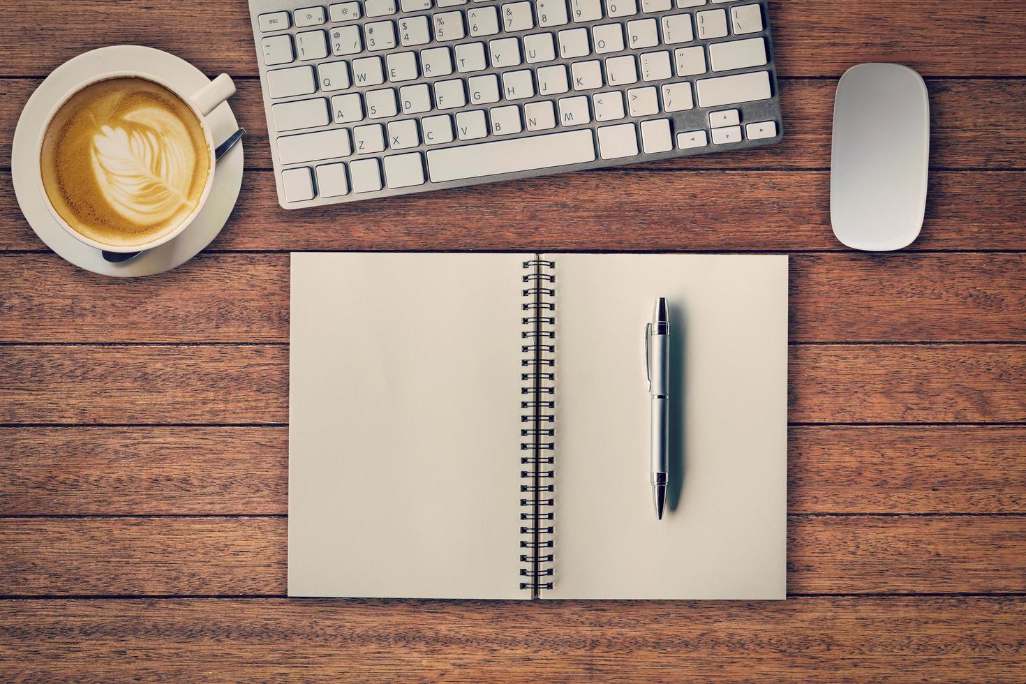 Office table with notepad, computer and coffee cup and computer mouse. View from above with copy space photo