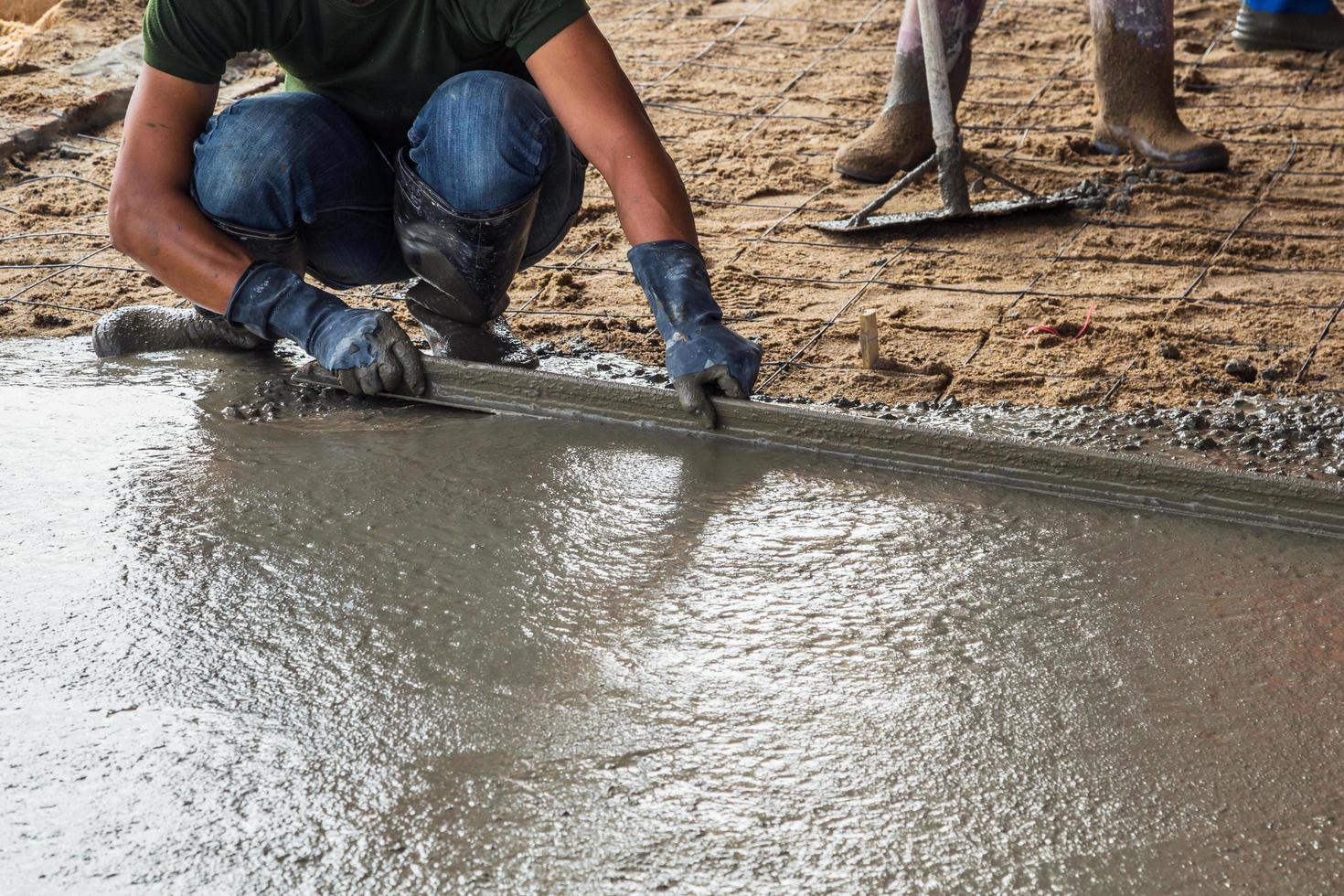 Man mason building a screed coat cement on floor photo