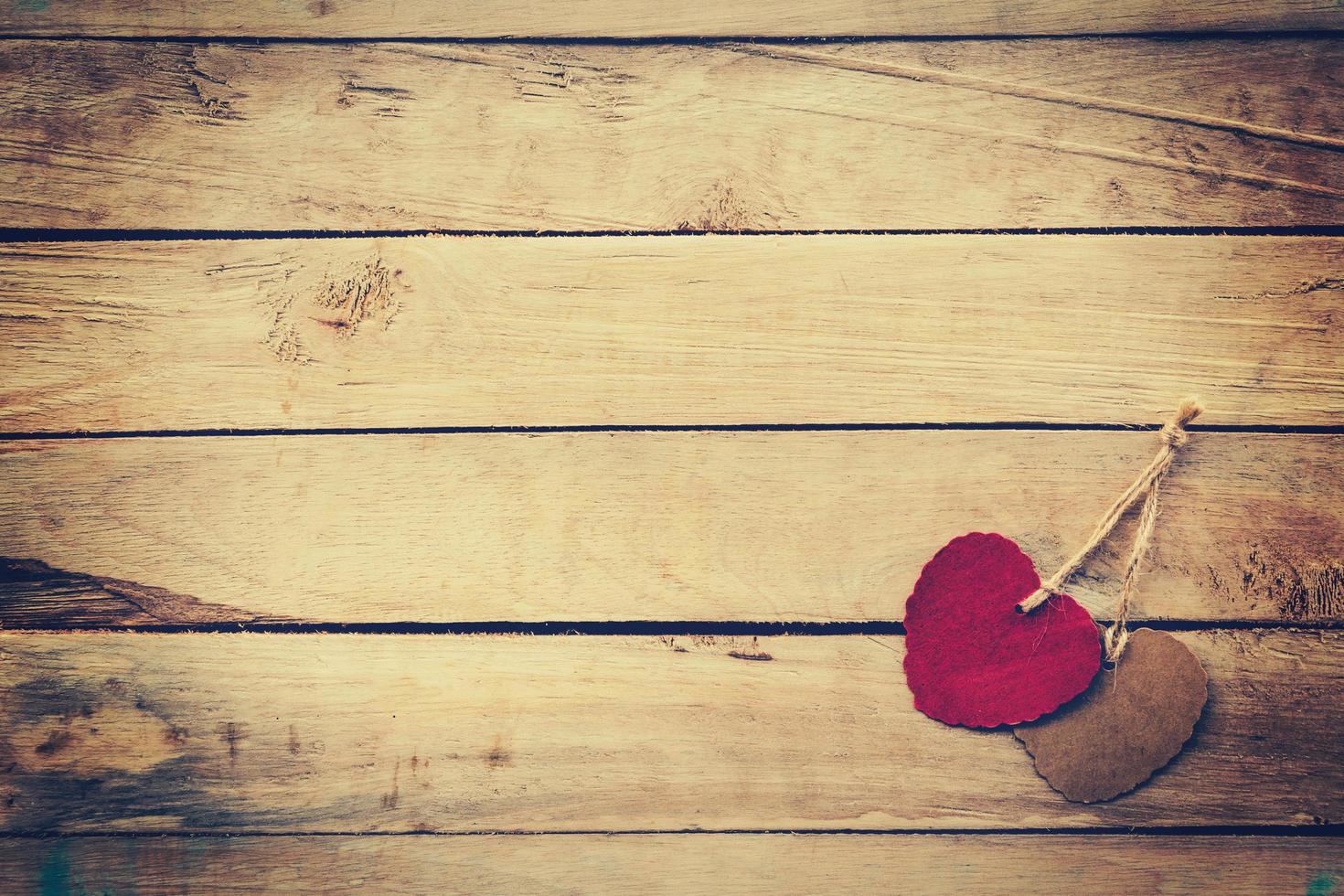 Two red and brown heart on wooden background with vintage style. photo