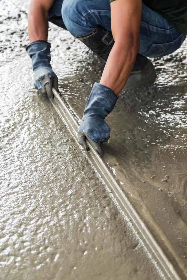 Man mason building a screed coat cement on floor photo