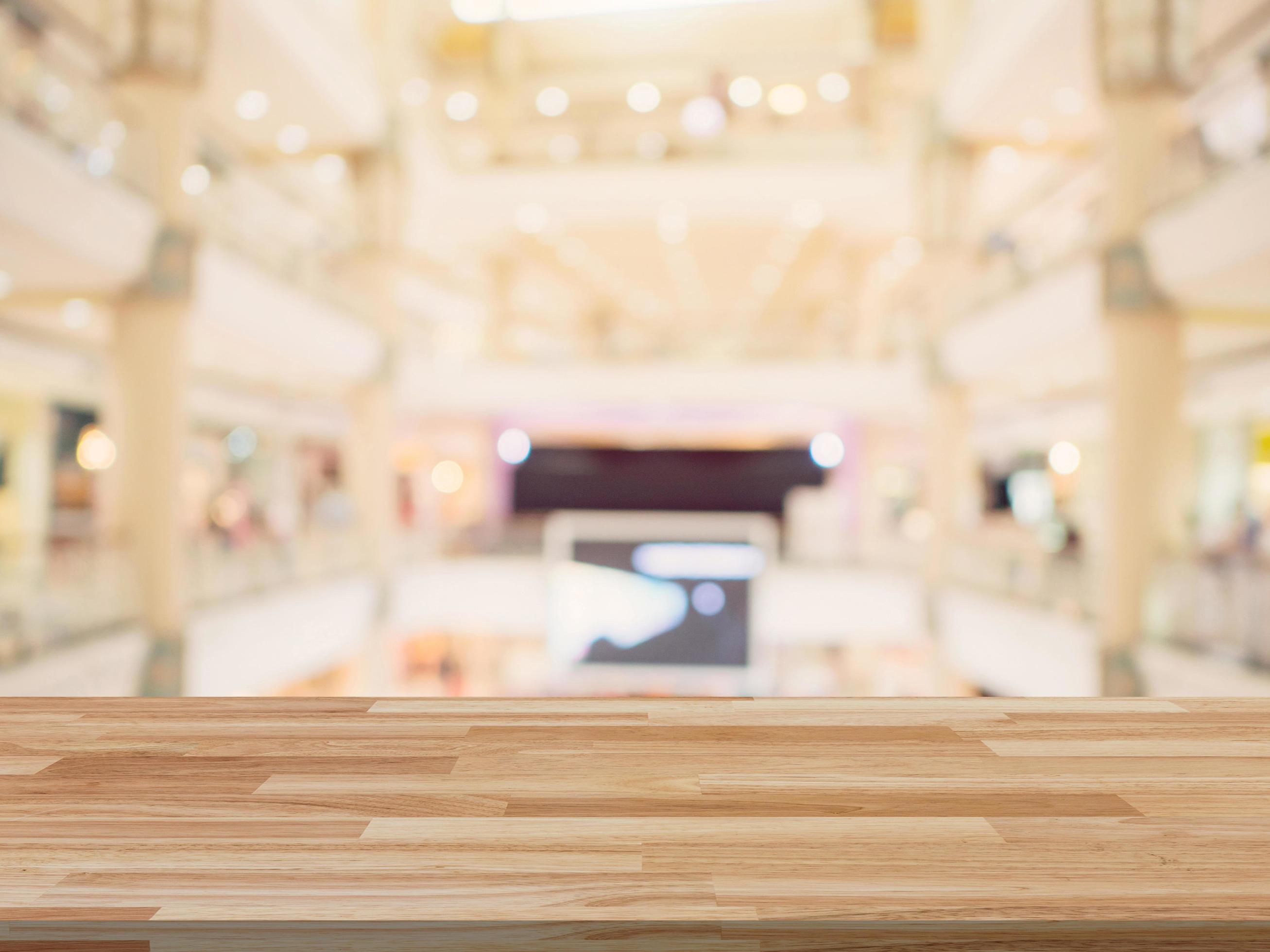 Wood table and shopping mall Blurred background with space for product