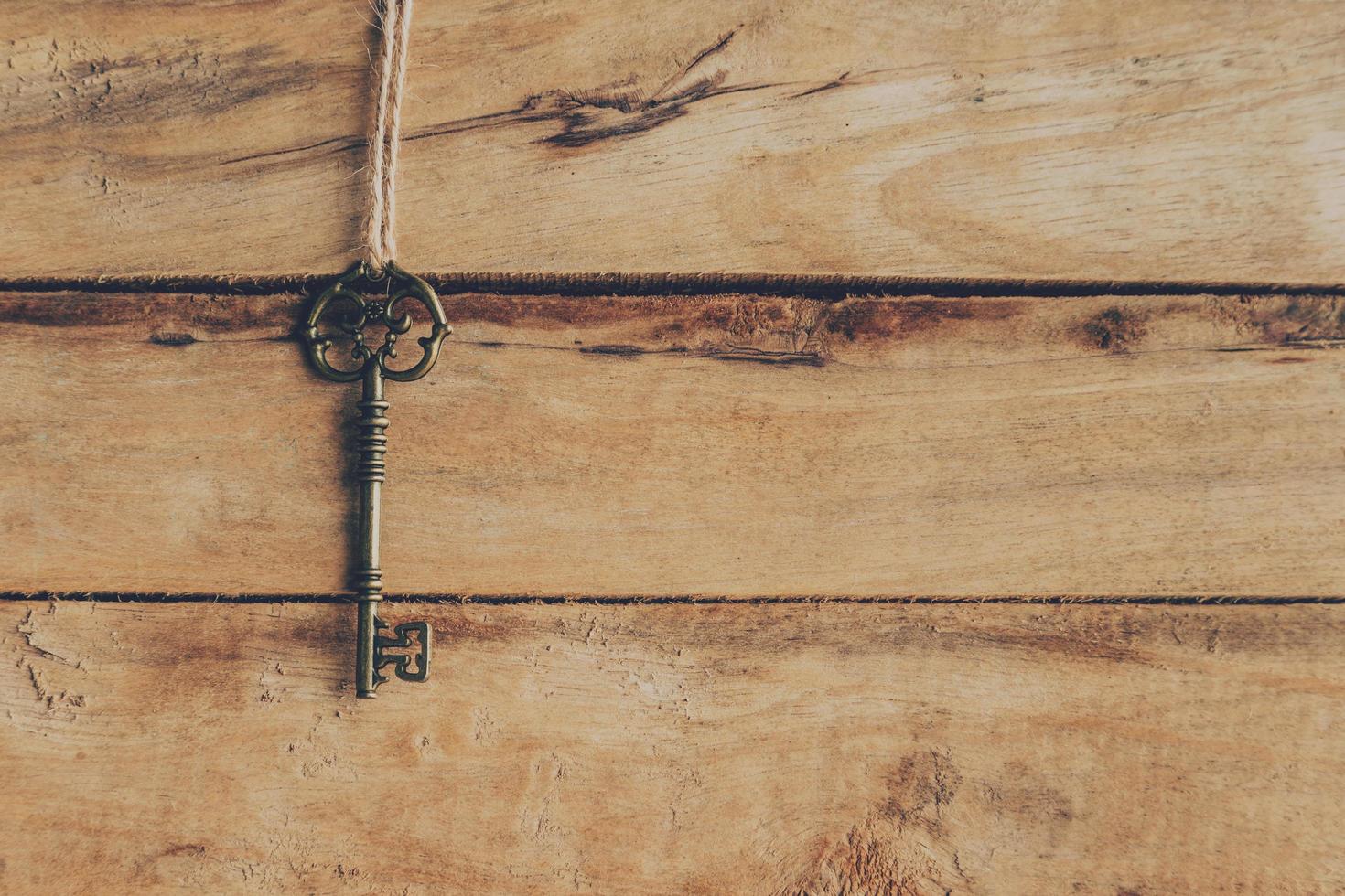 old key hanging on wood background texture with copy space photo