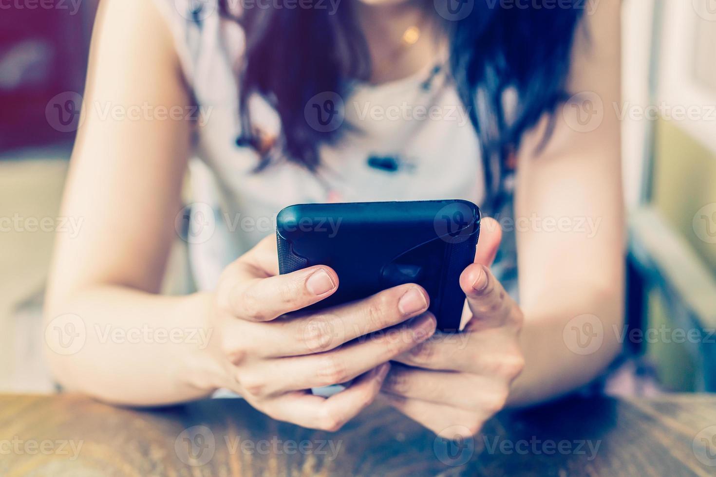 Hand woman using phone in coffee shop with depth of field. photo