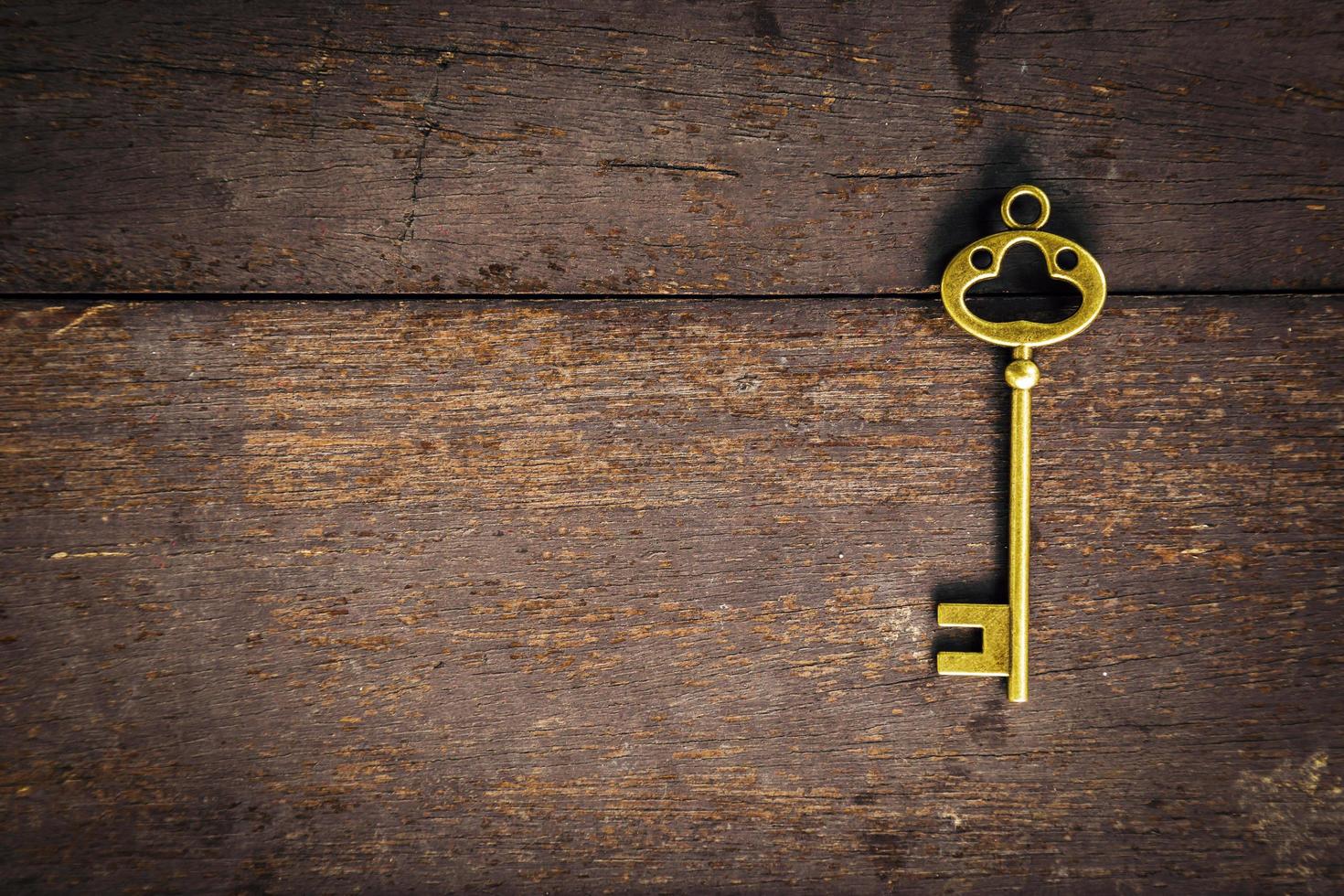 Old vintage key on wood texture background with space photo