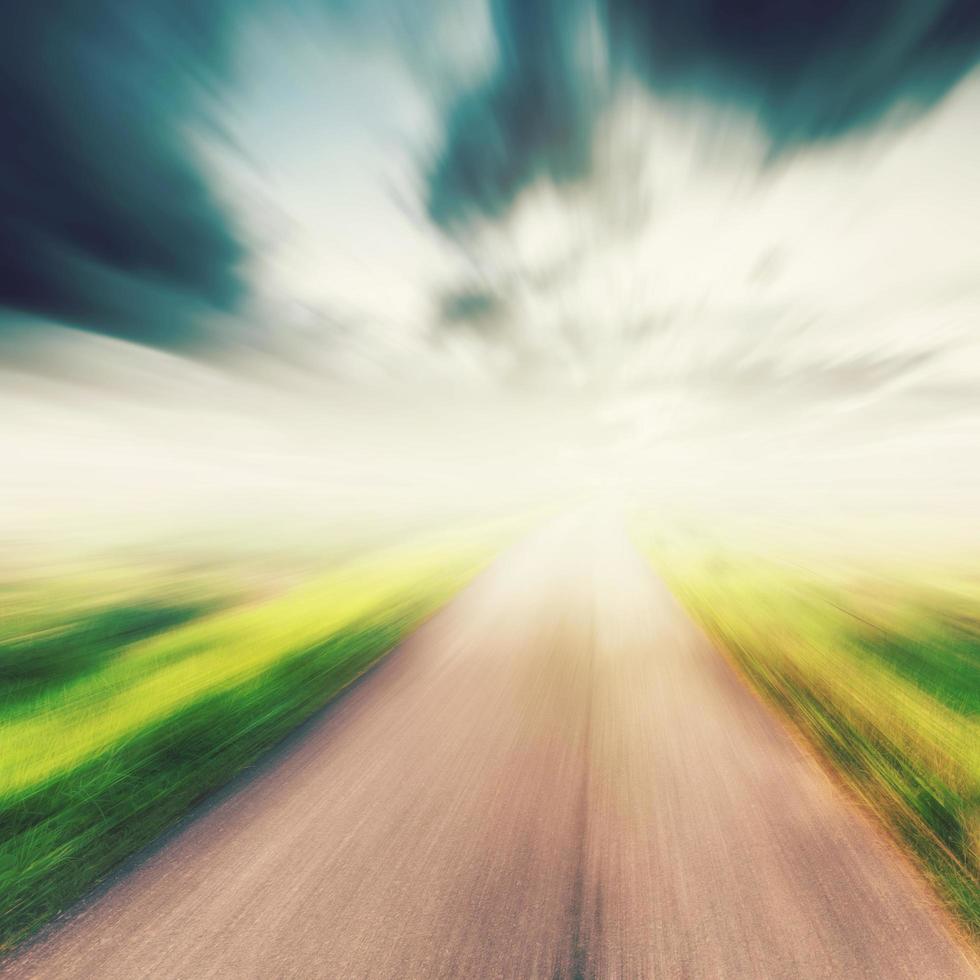 vintage photo of country asphalt road in motion blur at sunlight.