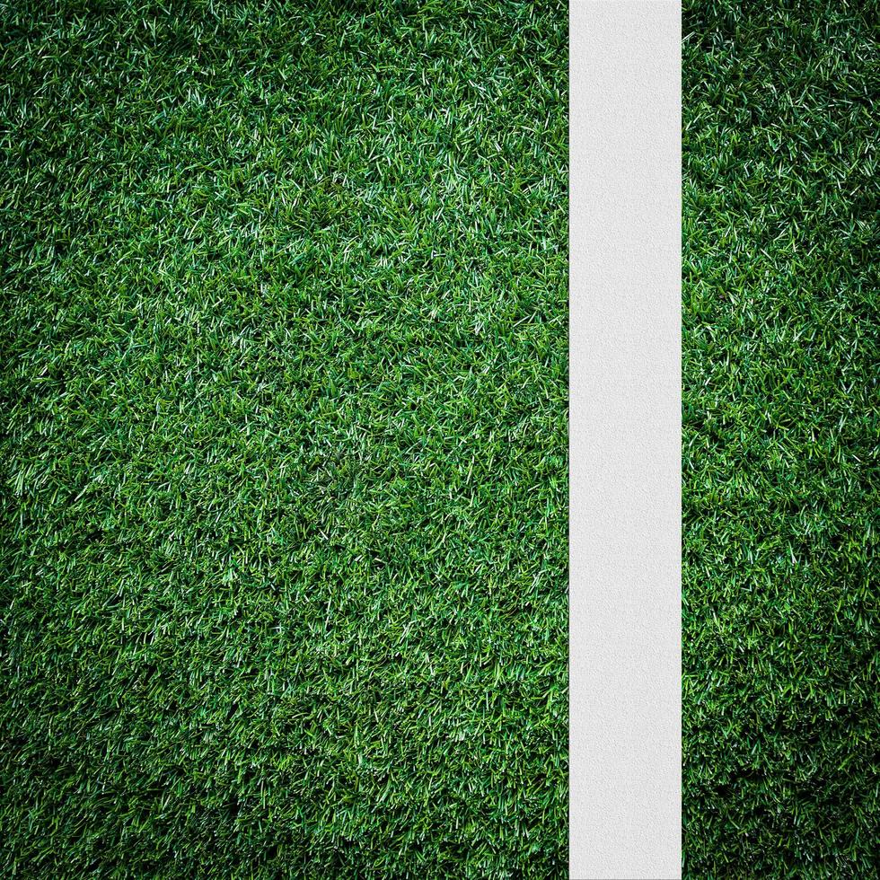 White stripe on the green soccer field from top view photo